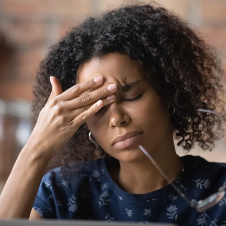 A woman massaging her forehead, trying to relieve a headache