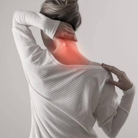 A woman holding her neck in pain, which is indicated with red highlighting